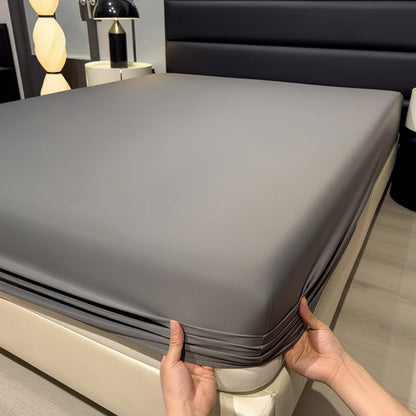 A gray fitted bed sheet is shown on a bed in a bedroom setting, with a person's hands pulling the corner of the sheet to demonstrate elasticity. The text 'Only bedsheet' is overlaid at the top.