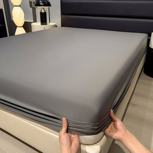 A gray fitted bed sheet is shown on a bed in a bedroom setting, with a person's hands pulling the corner of the sheet to demonstrate elasticity. The text 'Only bedsheet' is overlaid at the top.